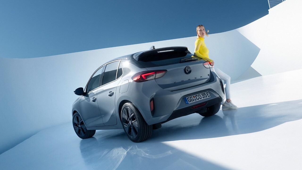 Hintere Seitenansicht des grauen Opel Corsa Electric mit schwarzen Felgen und Dach